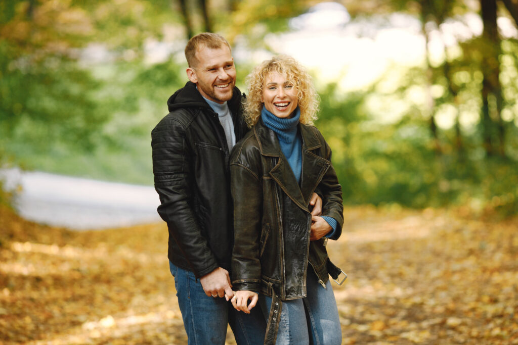 Romantic couple standing in a forest, hugging and posing for a p